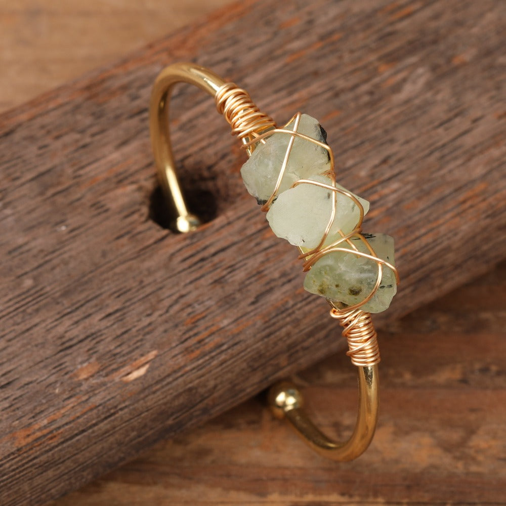 Experience the beauty of nature with Fiong Mma&#39;s Raw Crystal Bangle- A pair of our exquisitely designed Raw Crystal Bangles, handcrafted from a variety of 24 natural stones. Each bangle showcases the unique textures and colors of the stones, offering a blend of fashion and natural beauty, and reflecting a deep connection to the Earth.