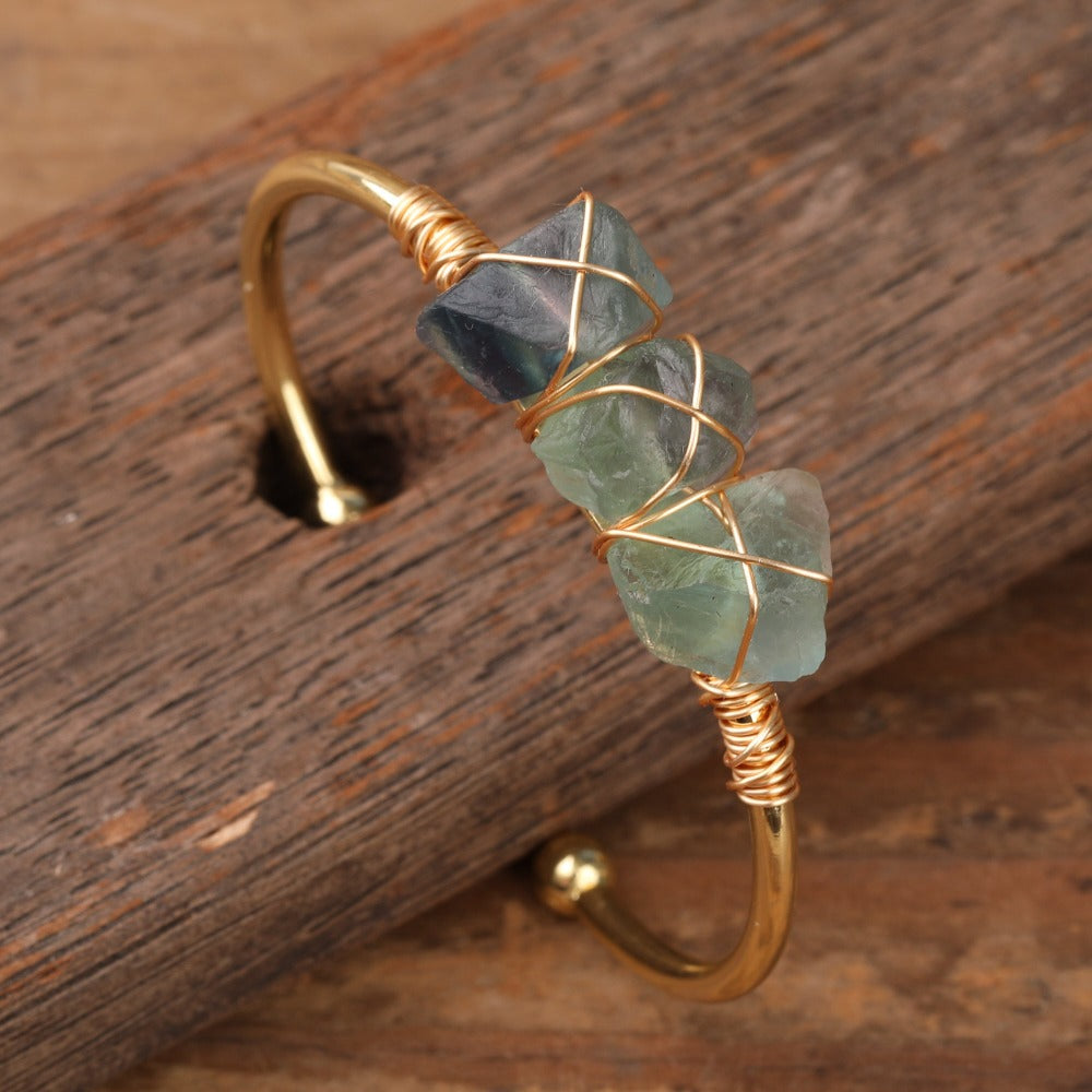 Experience the beauty of nature with Fiong Mma's Raw Crystal Bangle- A pair of our exquisitely designed Raw Crystal Bangles, handcrafted from a variety of 24 natural stones. Each bangle showcases the unique textures and colors of the stones, offering a blend of fashion and natural beauty, and reflecting a deep connection to the Earth.