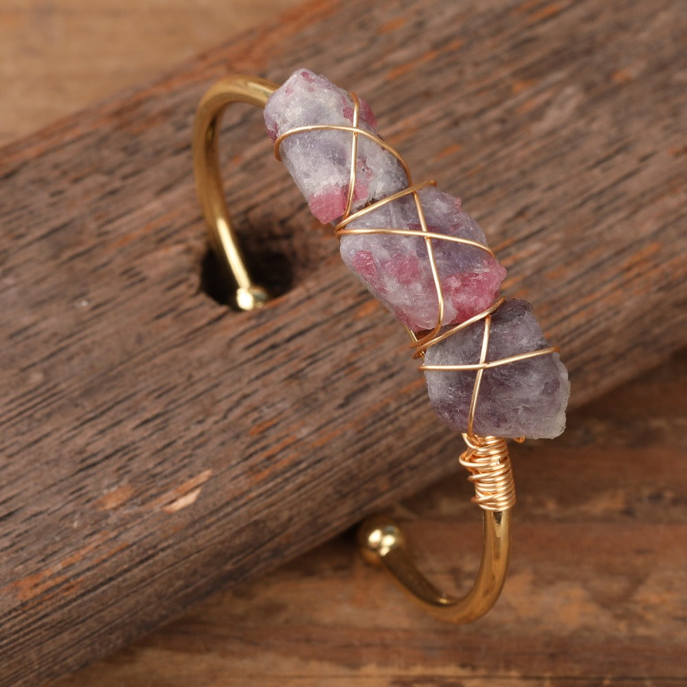 Experience the beauty of nature with Fiong Mma&#39;s Raw Crystal Bangle- A pair of our exquisitely designed Raw Crystal Bangles, handcrafted from a variety of 24 natural stones. Each bangle showcases the unique textures and colors of the stones, offering a blend of fashion and natural beauty, and reflecting a deep connection to the Earth.