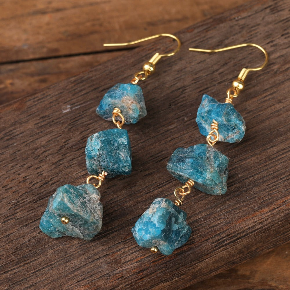 Experience the beauty of nature with Fiong Mma&#39;s Raw Crystal Earrings- A pair of our exquisitely designed Raw Crystal Earrings, handcrafted from a variety of 24 natural stones. Each earring showcases the unique textures and colors of the stones, offering a blend of fashion and natural beauty, and reflecting a deep connection to the Earth.