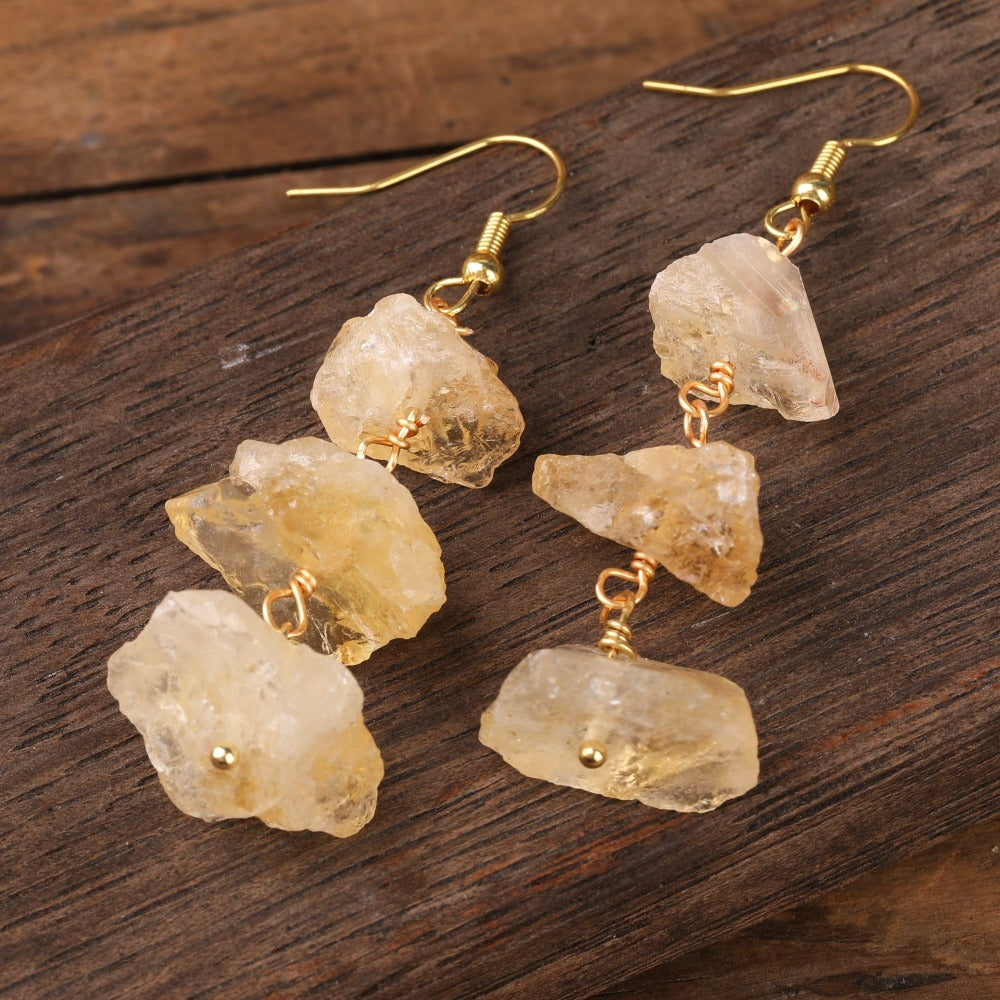 Experience the beauty of nature with Fiong Mma&#39;s Raw Crystal Earrings- A pair of our exquisitely designed Raw Crystal Earrings, handcrafted from a variety of 24 natural stones. Each earring showcases the unique textures and colors of the stones, offering a blend of fashion and natural beauty, and reflecting a deep connection to the Earth.