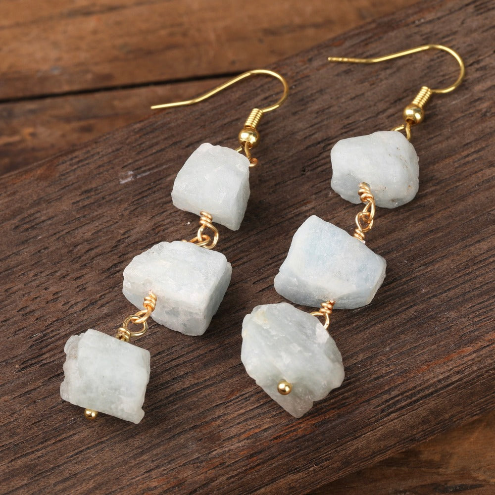 Experience the beauty of nature with Fiong Mma&#39;s Raw Crystal Earrings- A pair of our exquisitely designed Raw Crystal Earrings, handcrafted from a variety of 24 natural stones. Each earring showcases the unique textures and colors of the stones, offering a blend of fashion and natural beauty, and reflecting a deep connection to the Earth.