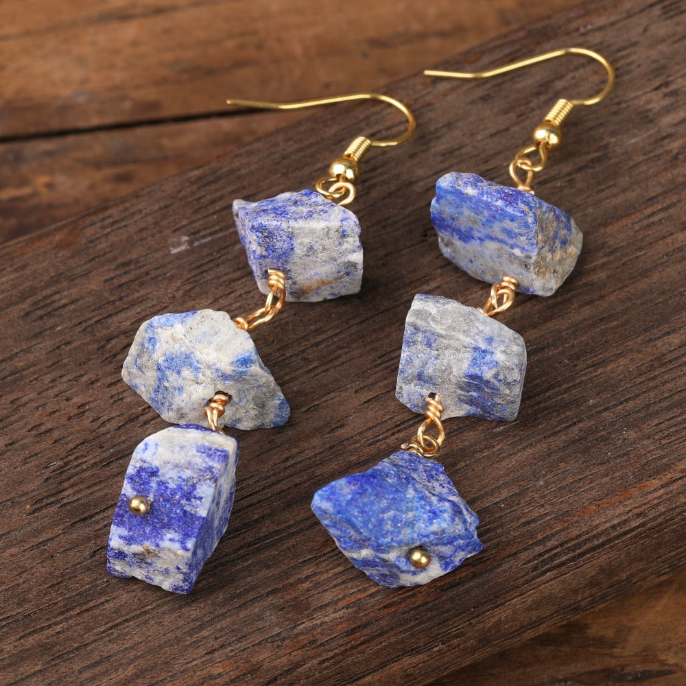 Experience the beauty of nature with Fiong Mma&#39;s Raw Crystal Earrings- A pair of our exquisitely designed Raw Crystal Earrings, handcrafted from a variety of 24 natural stones. Each earring showcases the unique textures and colors of the stones, offering a blend of fashion and natural beauty, and reflecting a deep connection to the Earth.