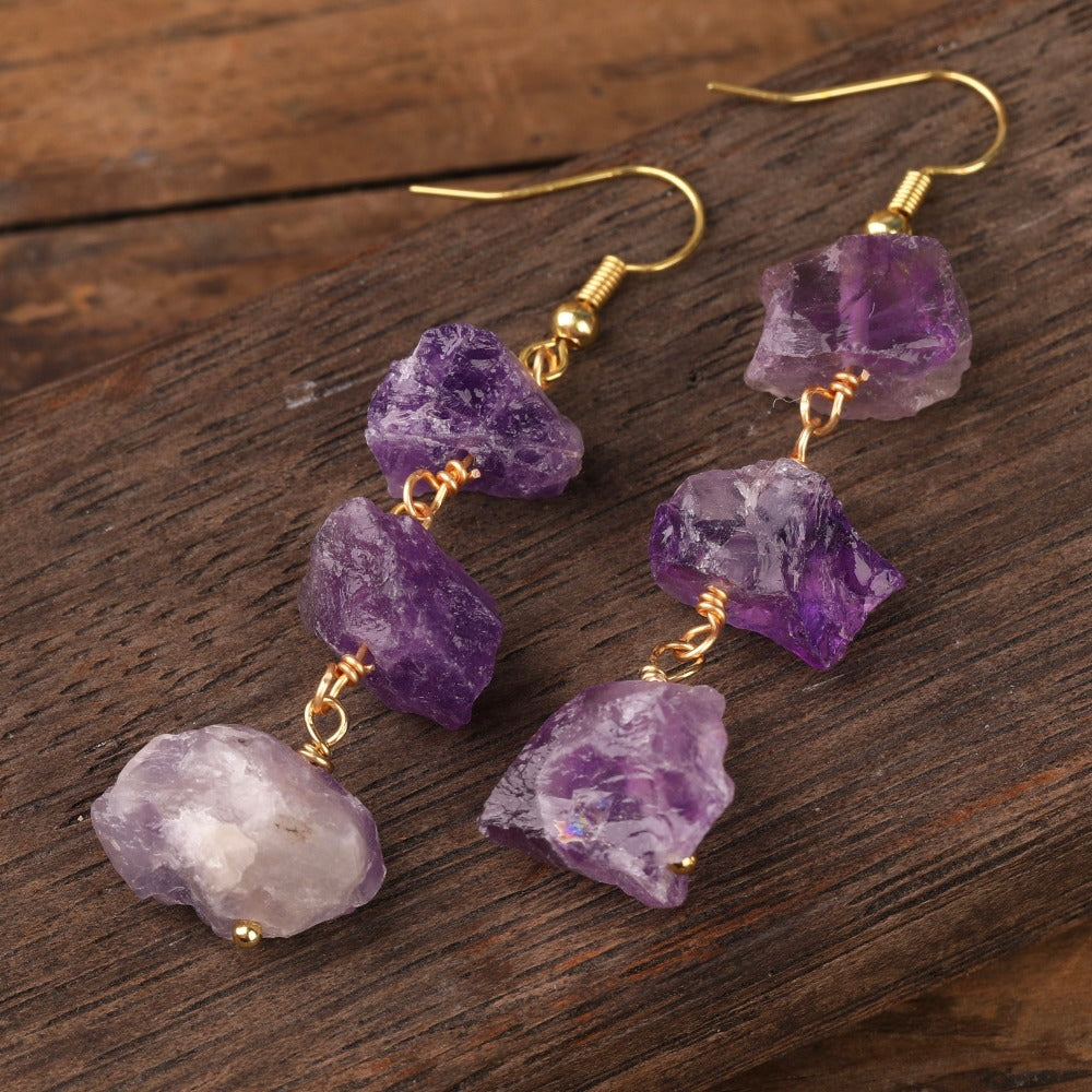 Experience the beauty of nature with Fiong Mma&#39;s Raw Crystal Earrings- A pair of our exquisitely designed Raw Crystal Earrings, handcrafted from a variety of 24 natural stones. Each earring showcases the unique textures and colors of the stones, offering a blend of fashion and natural beauty, and reflecting a deep connection to the Earth.