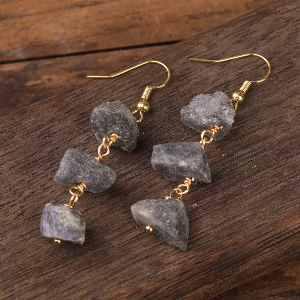 Experience the beauty of nature with Fiong Mma&#39;s Raw Crystal Earrings- A pair of our exquisitely designed Raw Crystal Earrings, handcrafted from a variety of 24 natural stones. Each earring showcases the unique textures and colors of the stones, offering a blend of fashion and natural beauty, and reflecting a deep connection to the Earth.