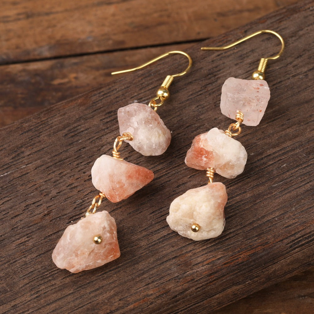 Experience the beauty of nature with Fiong Mma's Raw Crystal Earrings- A pair of our exquisitely designed Raw Crystal Earrings, handcrafted from a variety of 24 natural stones. Each earring showcases the unique textures and colors of the stones, offering a blend of fashion and natural beauty, and reflecting a deep connection to the Earth.