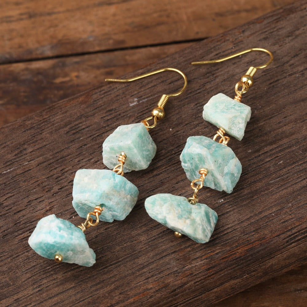 Experience the beauty of nature with Fiong Mma&#39;s Raw Crystal Earrings- A pair of our exquisitely designed Raw Crystal Earrings, handcrafted from a variety of 24 natural stones. Each earring showcases the unique textures and colors of the stones, offering a blend of fashion and natural beauty, and reflecting a deep connection to the Earth.