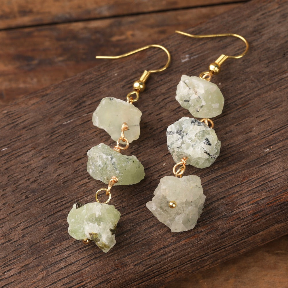 Experience the beauty of nature with Fiong Mma&#39;s Raw Crystal Earrings- A pair of our exquisitely designed Raw Crystal Earrings, handcrafted from a variety of 24 natural stones. Each earring showcases the unique textures and colors of the stones, offering a blend of fashion and natural beauty, and reflecting a deep connection to the Earth.