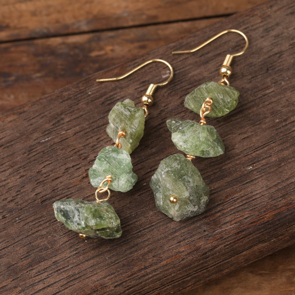 Experience the beauty of nature with Fiong Mma&#39;s Raw Crystal Earrings- A pair of our exquisitely designed Raw Crystal Earrings, handcrafted from a variety of 24 natural stones. Each earring showcases the unique textures and colors of the stones, offering a blend of fashion and natural beauty, and reflecting a deep connection to the Earth.